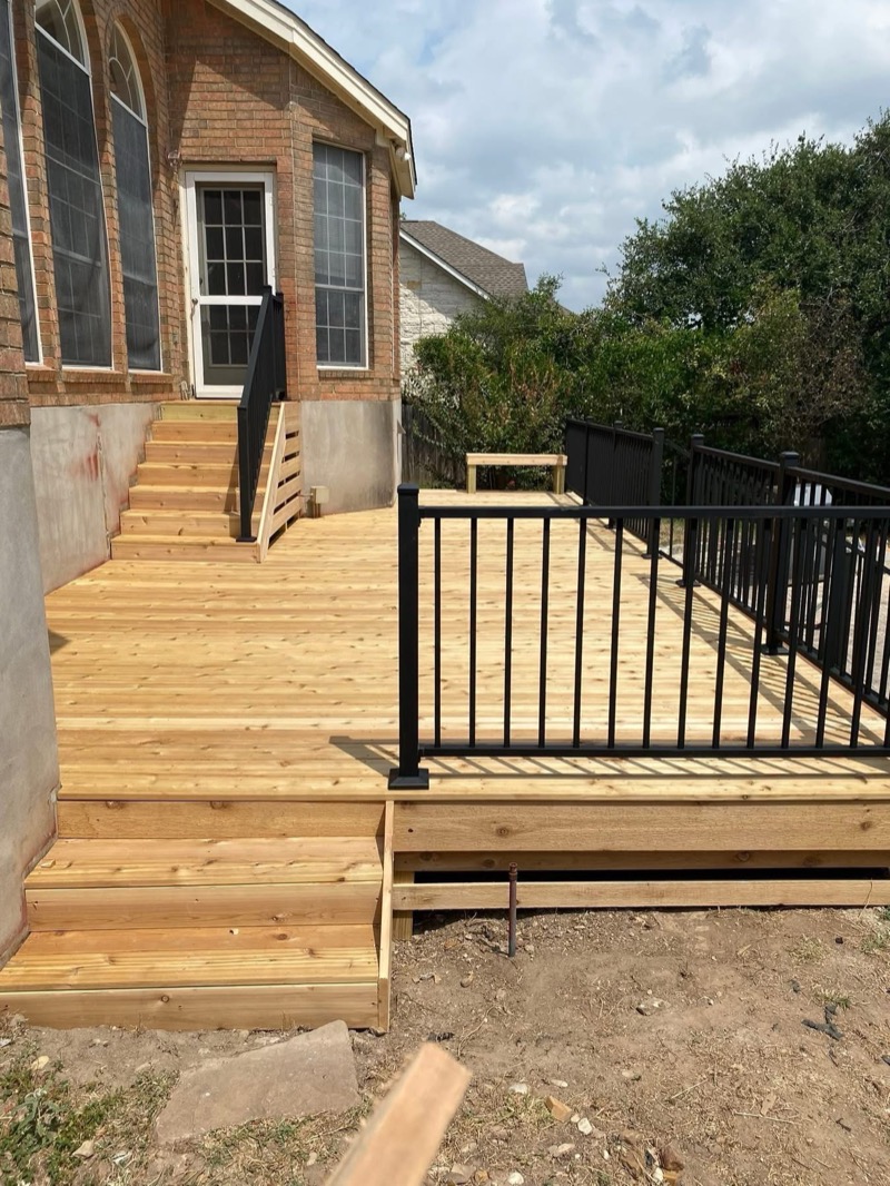 Harley Construction deck build — cedar decking with black iron railing